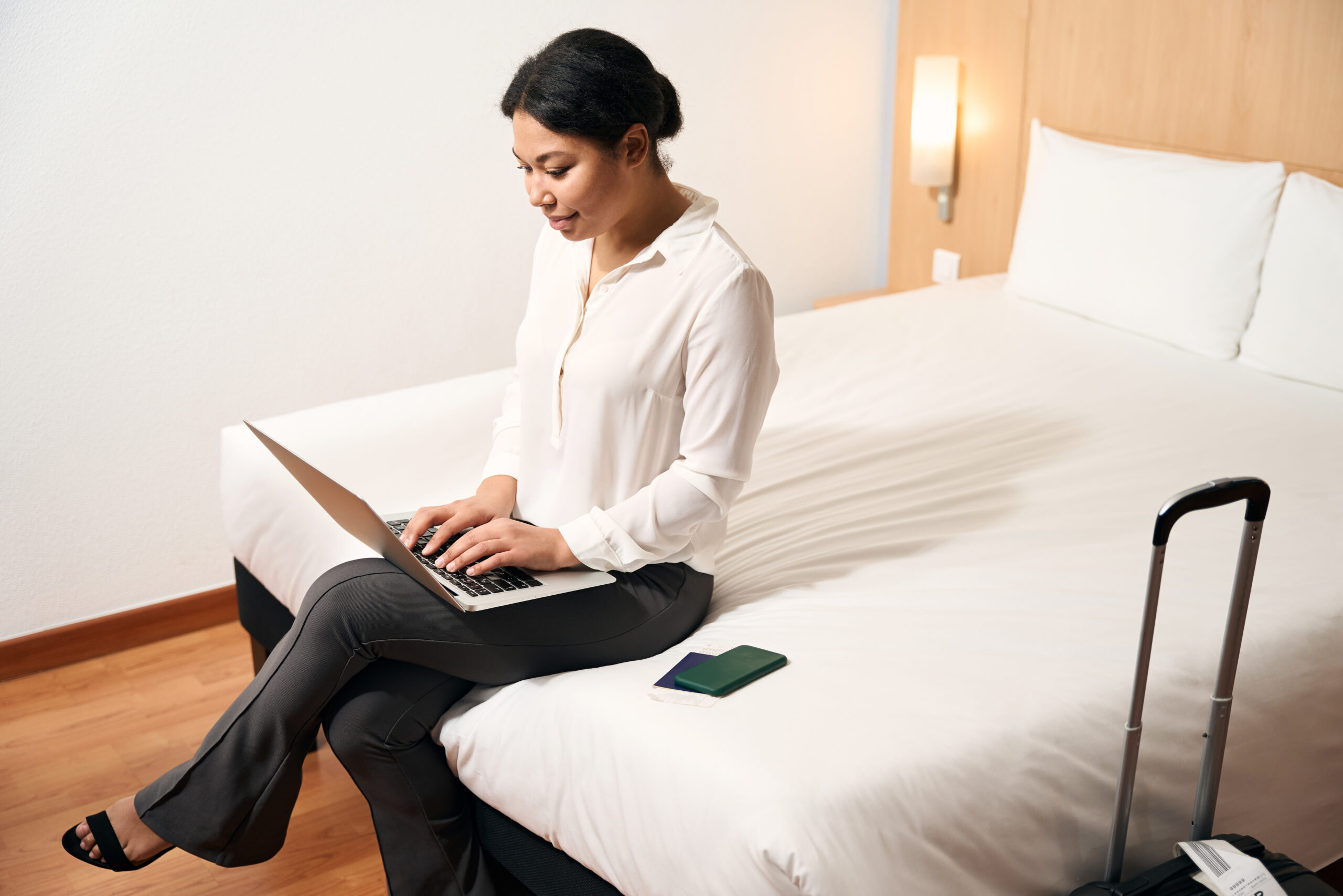 Woman using laptop in hotel room